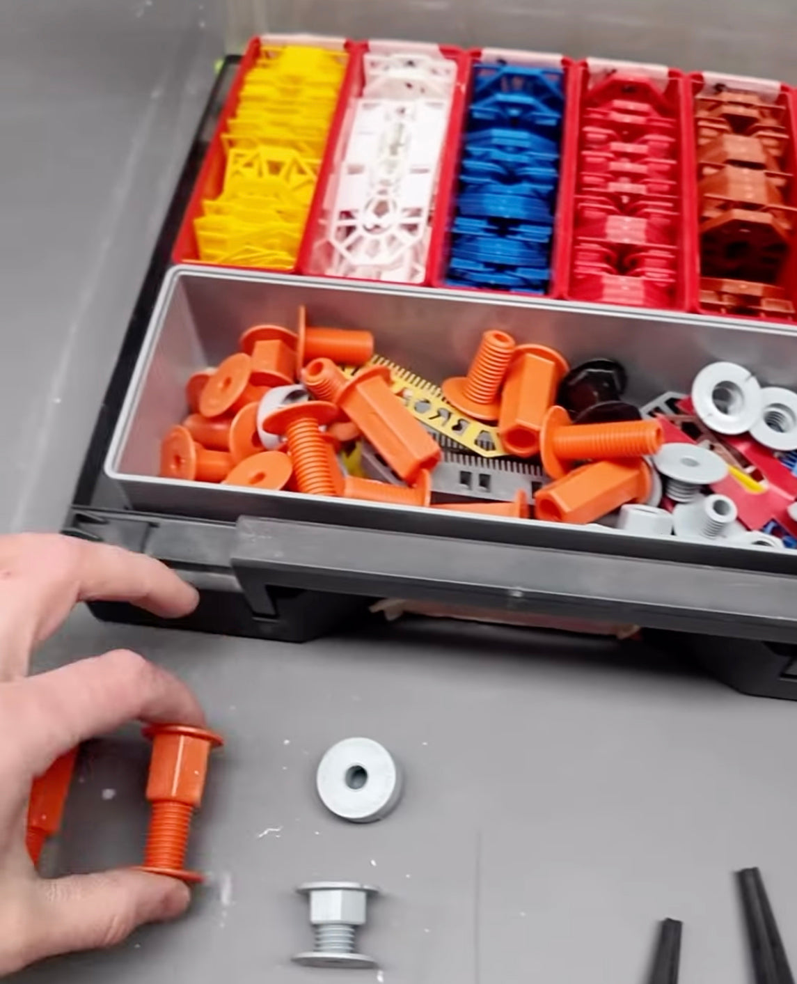 Professional kitchen cabinet fixing components and adjustable spacer fixings organised in a toolbox during a kitchen installation setup